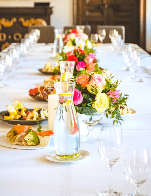 Lange Festtafel mit Blumenschmuck und Gedecken