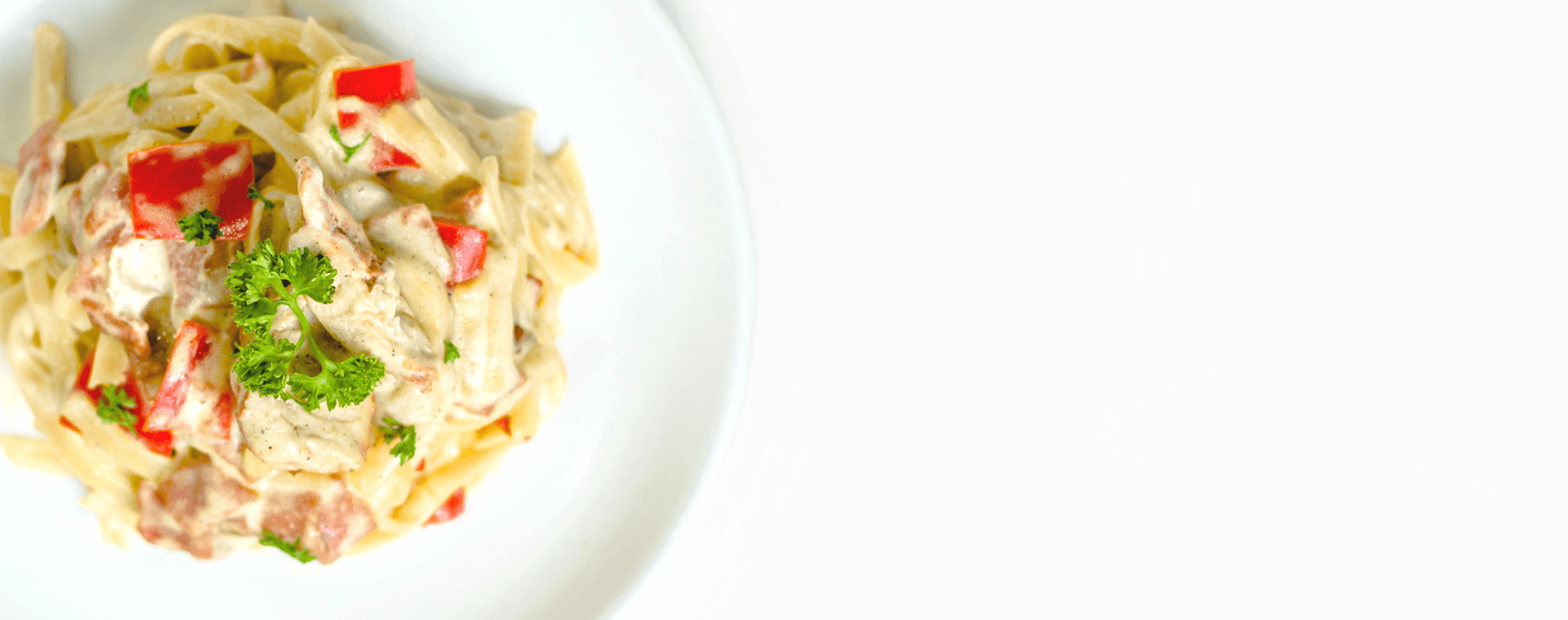 Teller mit cremiger Pasta, Paprika und frischer Petersilie