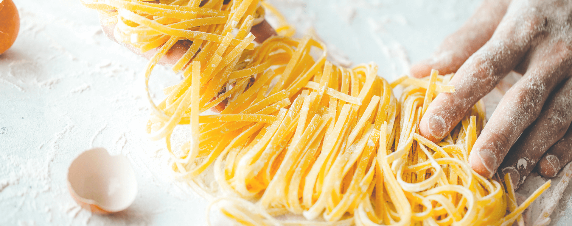 Frisch geschnittene Tagliatelle auf bemehlter Arbeitsfläche